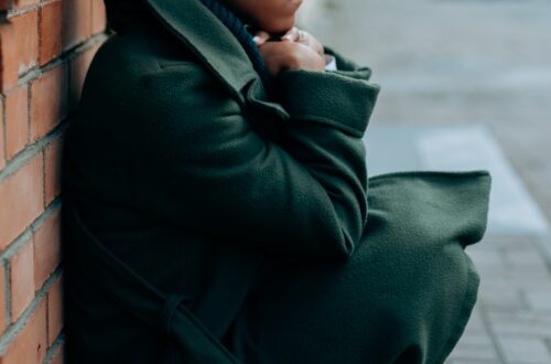 Blame-Shifting - woman crouched down against a brick wall